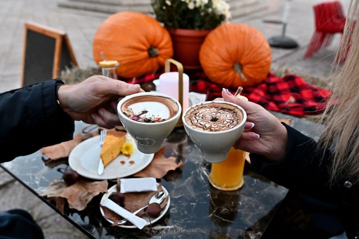 Koffiekopjes in handen met herfstsferen