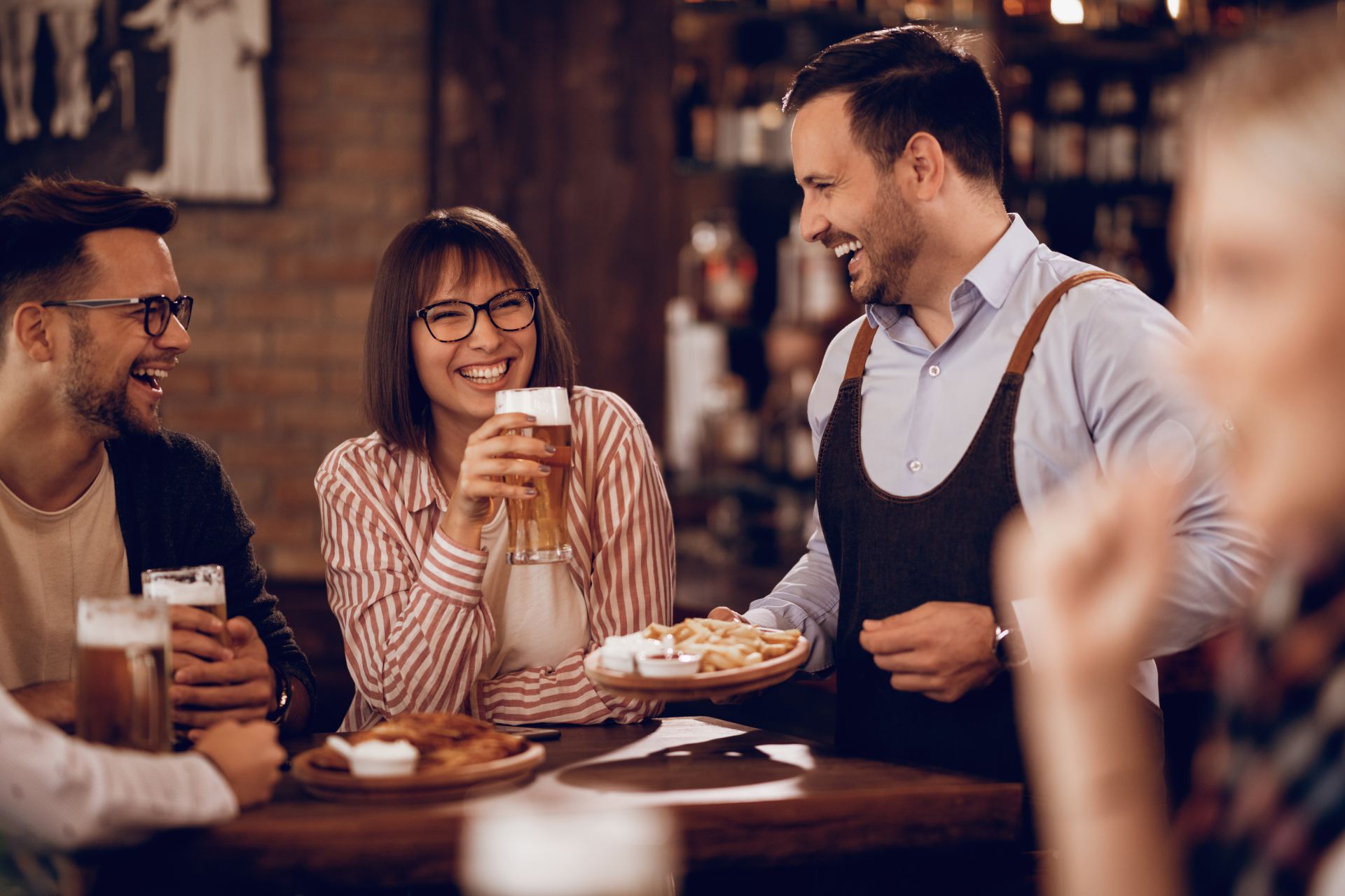 Blije klanten in café met fingerfood en bier
