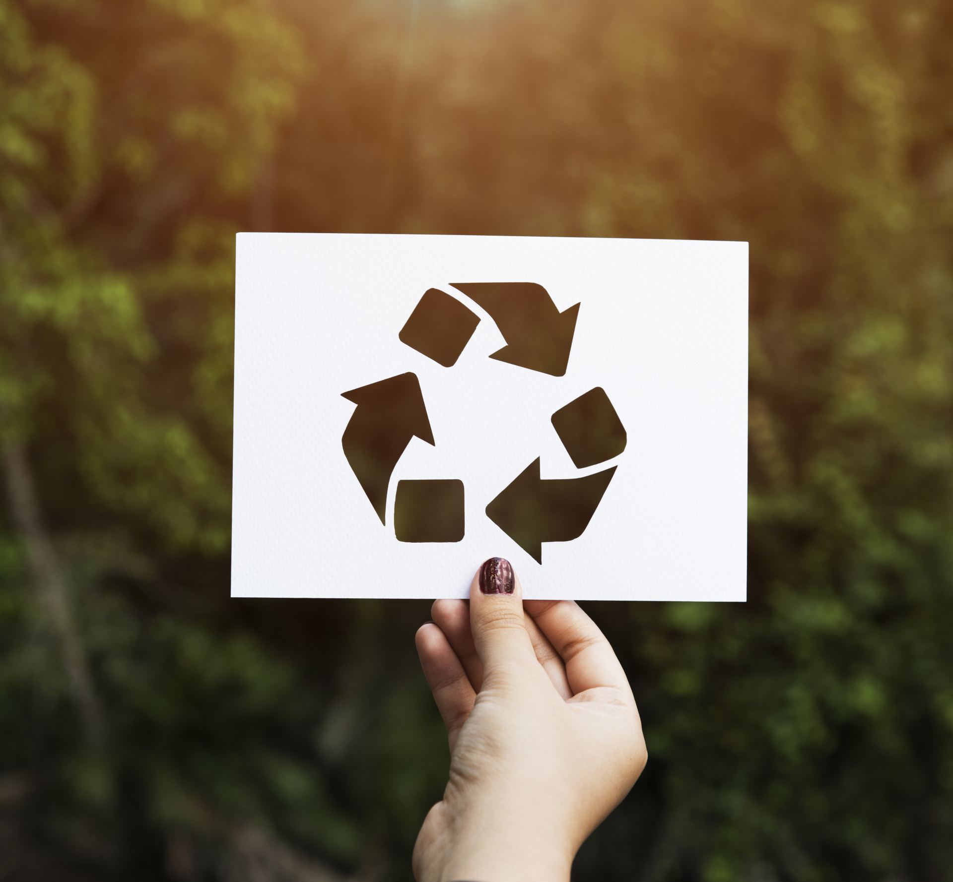 Papier met recycle logo in buitenlucht